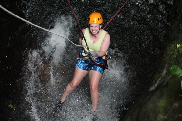 Photo of me, the author of this post repelling down a waterfall on top of a volcano and trying to look less fat..